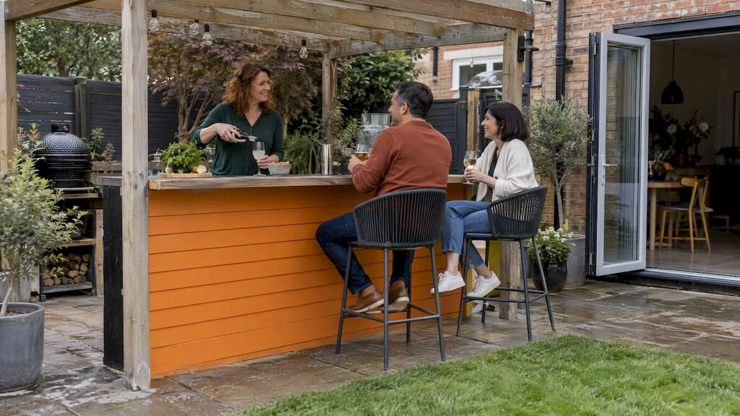 Host serving guests at a covered garden bar